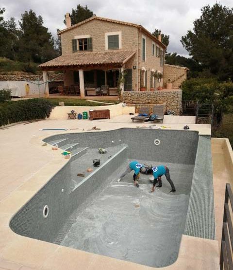 Construcciones y Reformas Puchaicela hombres construyendo piscina en exterior de casa